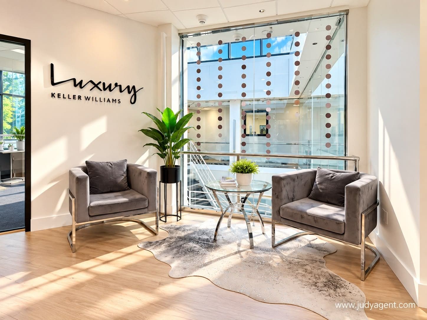 Seating area beneath a Keller Williams Luxury sign, with two armchairs by a window onto the atrium